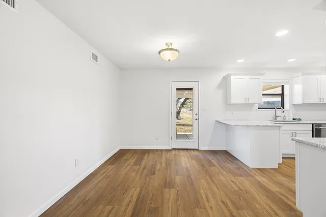a view of kitchen with wooden floor and electronic appliances