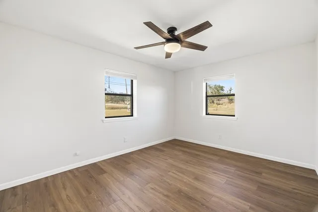 a view of a big room with wooden floor closet and windows