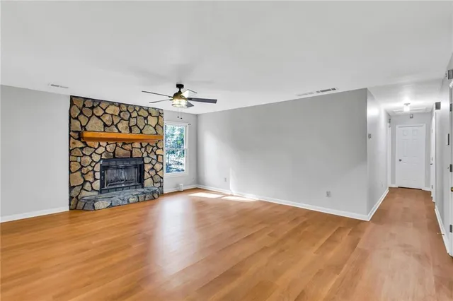 a view of an empty room with a fireplace and a window