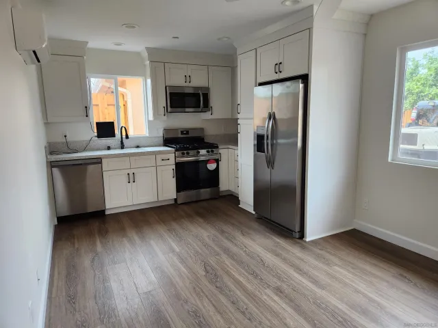 a kitchen with stainless steel appliances a refrigerator stove microwave and sink