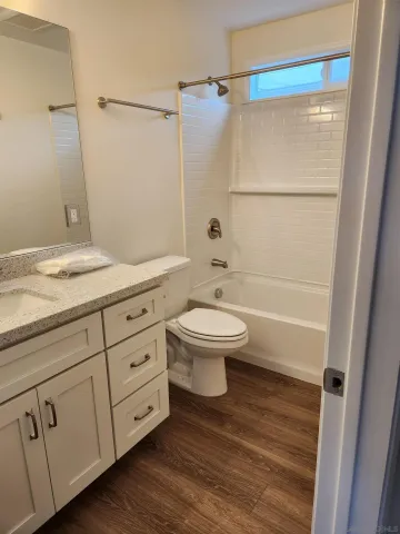 a bathroom with a granite countertop sink a toilet and shower