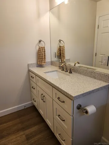 a bathroom with a granite countertop sink and a mirror