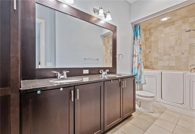 a view of a hallway with wooden floor and a bathroom