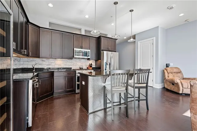a kitchen with stainless steel appliances granite countertop a sink stove and refrigerator