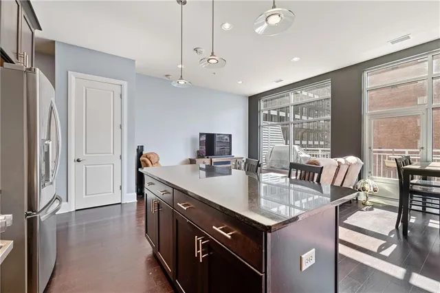 a kitchen with stainless steel appliances kitchen island granite countertop a stove sink and cabinets