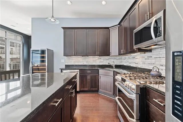 a living room with furniture a flat screen tv and a floor to ceiling window