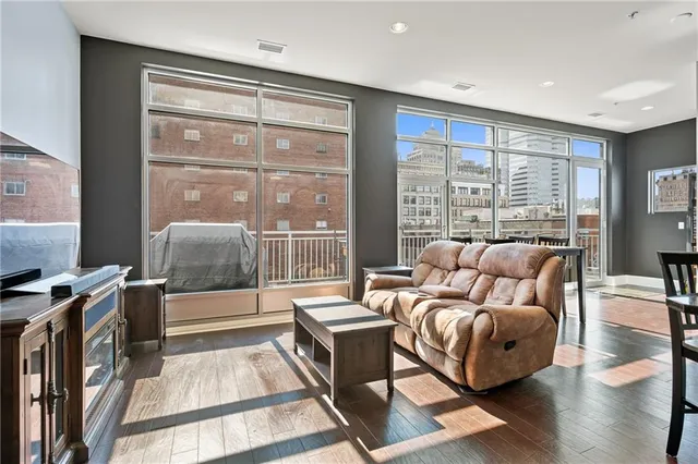 a living room filled with furniture and kitchen view