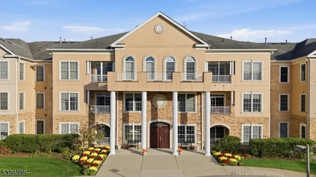 a view of a white house with large windows and yard