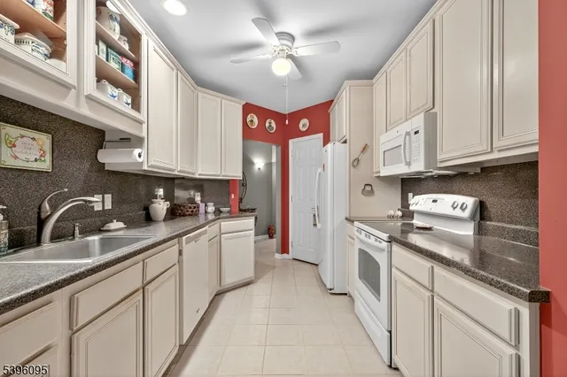 a kitchen with stainless steel appliances granite countertop a sink a stove and cabinets