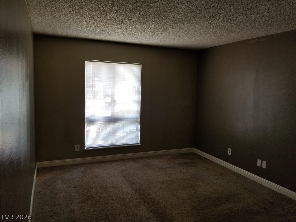 1515 East Reno Avenue, Unit A103 Las Vegas, NV 89119 - Photo 14 of 16 This cozy bedroom provides a comfortable retreat with soft carpet and a sun-filled window.