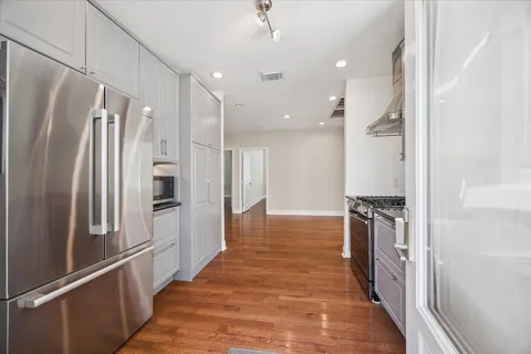 a kitchen with stainless steel appliances a refrigerator and a stove top oven