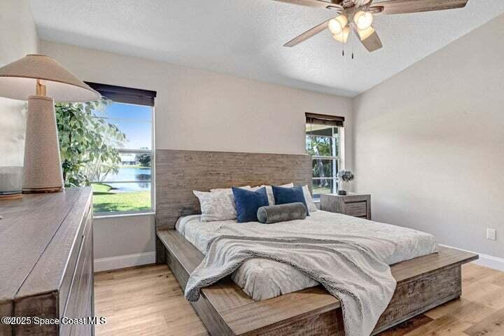 3360 Holly Springs Road Melbourne, FL 32934 - Photo 15 of 30 a bedroom with a large bed and a chandelier