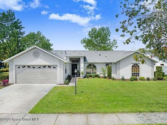 3360 Holly Springs Road Melbourne, FL 32934 - Photo 2 of 30 a front view of a house with a yard and garage