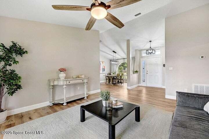 3360 Holly Springs Road Melbourne, FL 32934 - Photo 3 of 30 a living room with furniture and a chandelier