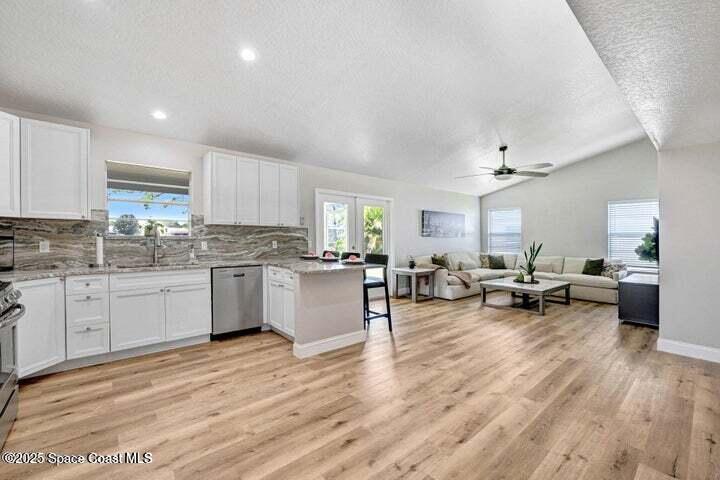 3360 Holly Springs Road Melbourne, FL 32934 - Photo 9 of 30 a kitchen with sink cabinets and wooden floor