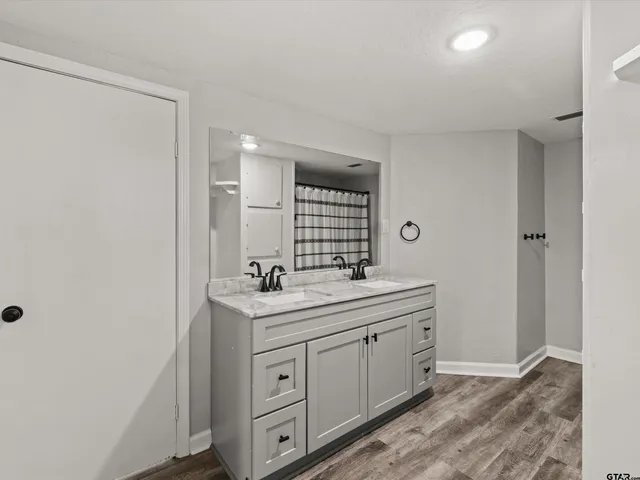 a spacious bathroom with a double vanity sink a mirror and a