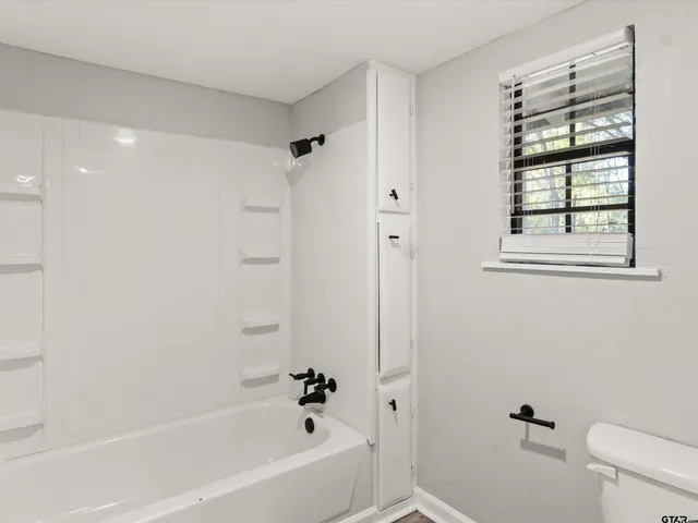 a white bath tub sitting next to a white toilet