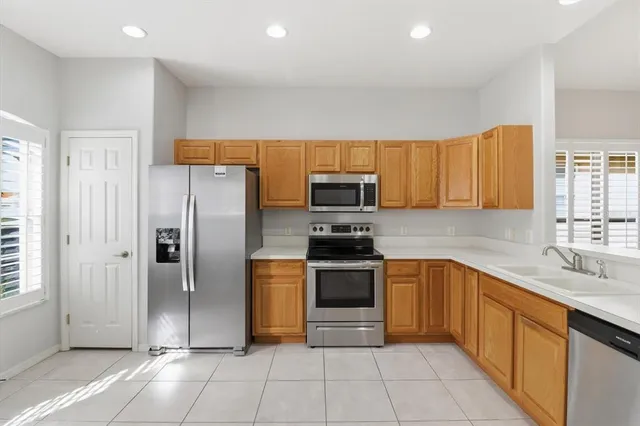 a kitchen with stainless steel appliances granite countertop a refrigerator and a sink