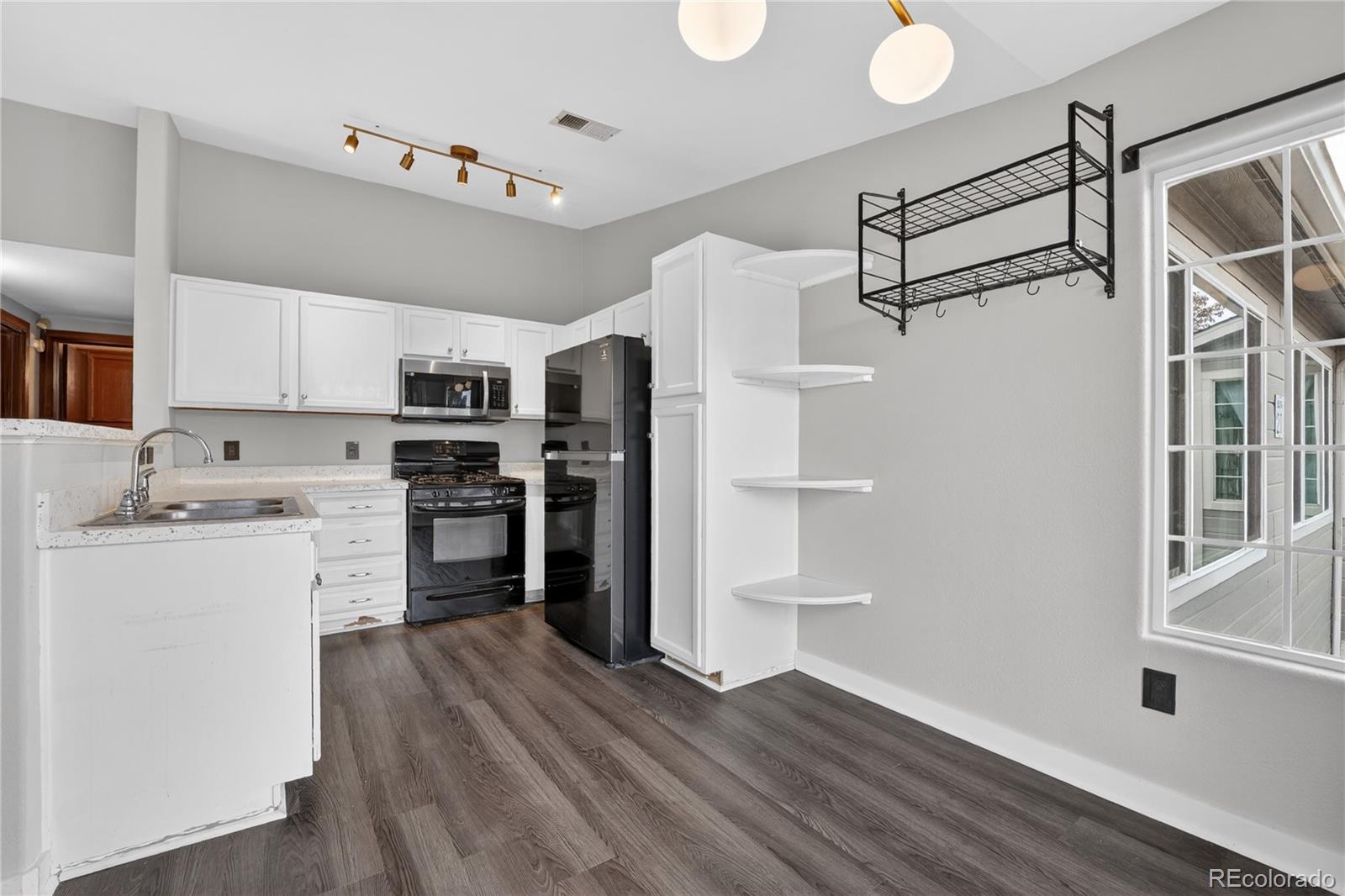 8406 Pebble Creek Way, Unit 204 Highlands Ranch, CO 80126 - Photo 11 of 29 a kitchen with stainless steel appliances a refrigerator and a stove top oven