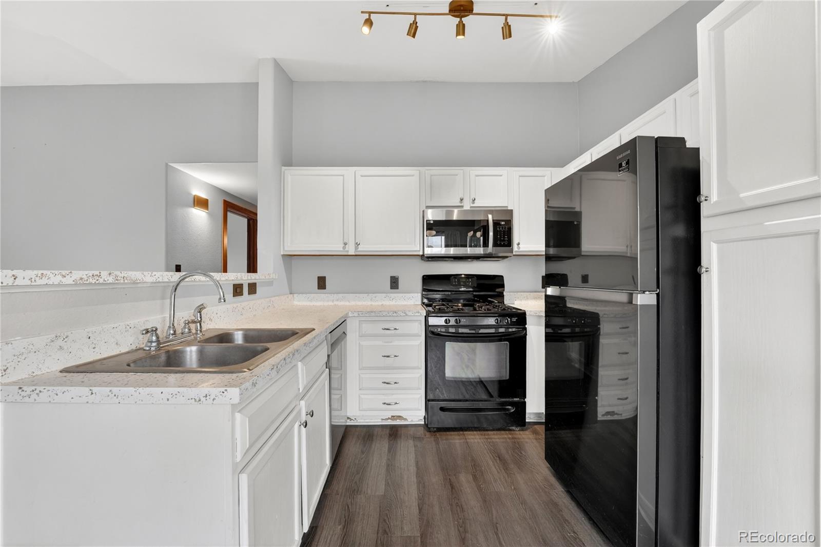 8406 Pebble Creek Way, Unit 204 Highlands Ranch, CO 80126 - Photo 12 of 29 a kitchen with kitchen island granite countertop a sink stainless steel appliances and cabinets