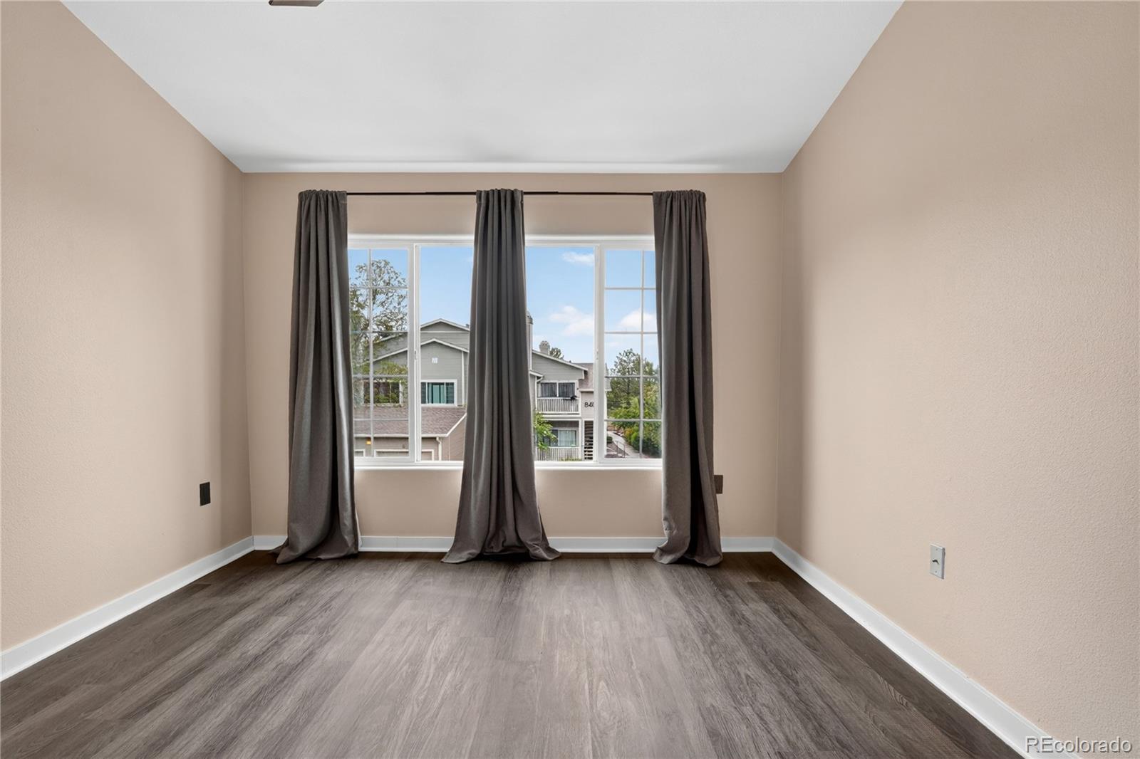 8406 Pebble Creek Way, Unit 204 Highlands Ranch, CO 80126 - Photo 14 of 29 an empty room with wooden floor and windows