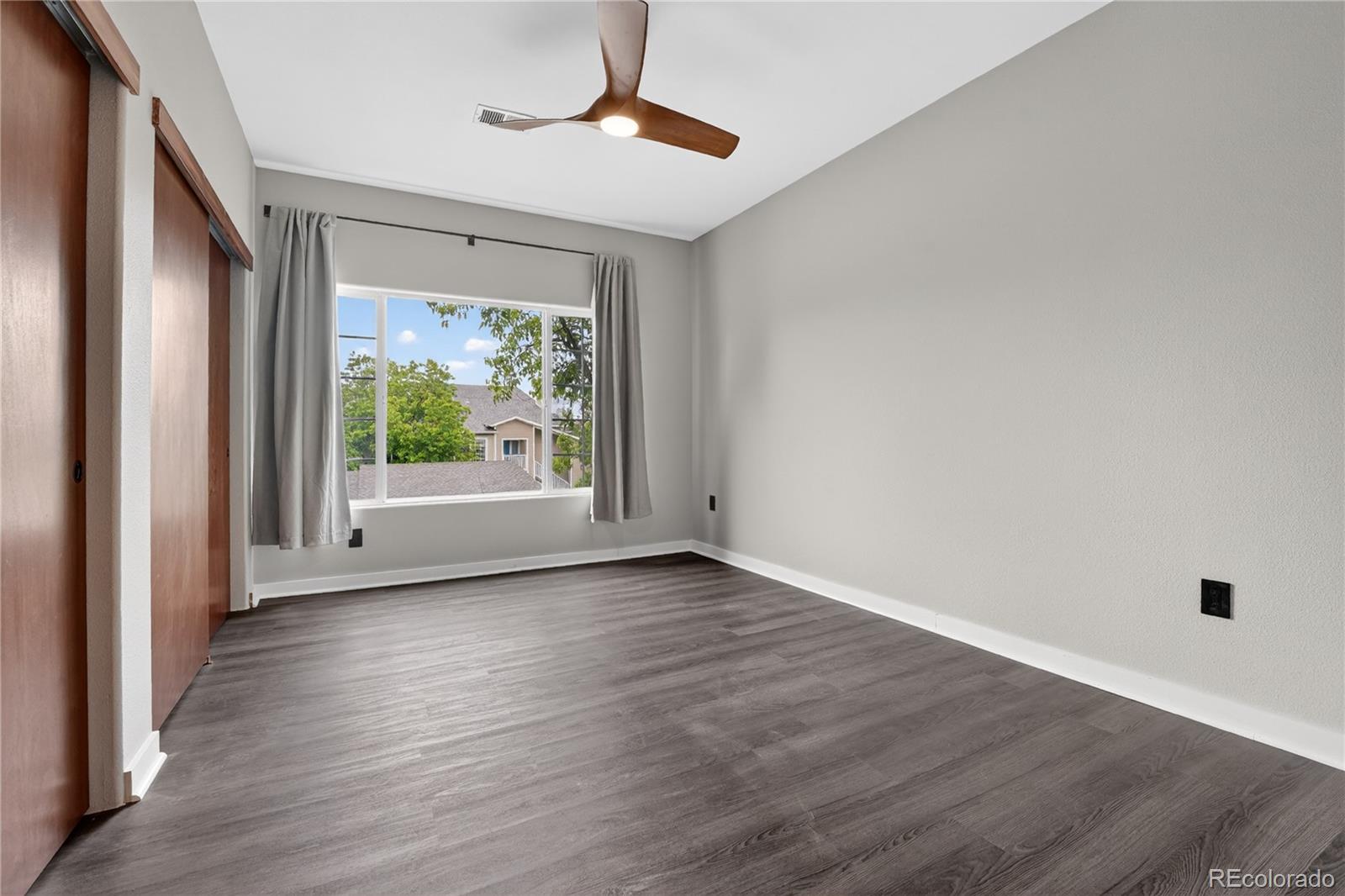8406 Pebble Creek Way, Unit 204 Highlands Ranch, CO 80126 - Photo 19 of 29 a view of an empty room with wooden floor and a window