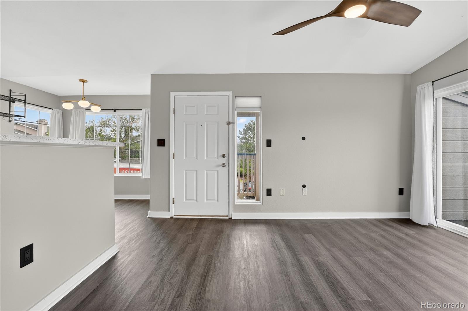 8406 Pebble Creek Way, Unit 204 Highlands Ranch, CO 80126 - Photo 6 of 29 an empty room with wooden floor and windows