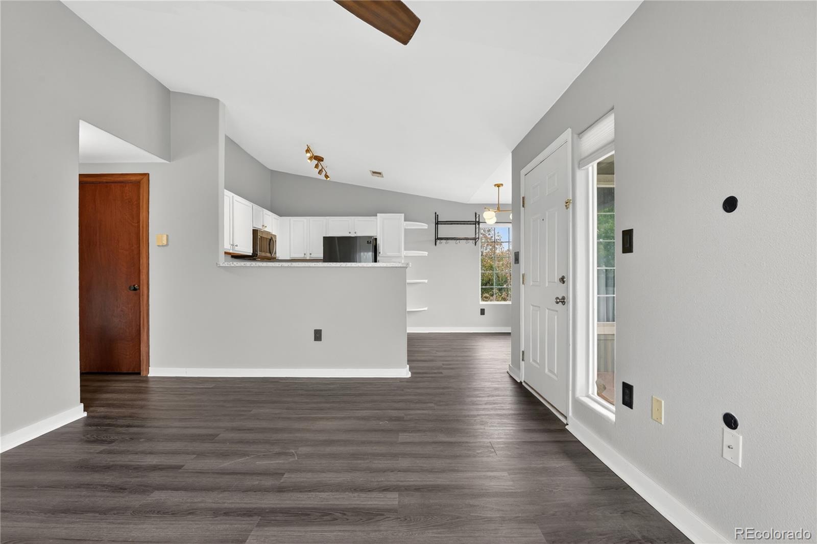 8406 Pebble Creek Way, Unit 204 Highlands Ranch, CO 80126 - Photo 10 of 29 a view of a hallway with wooden floor and staircase