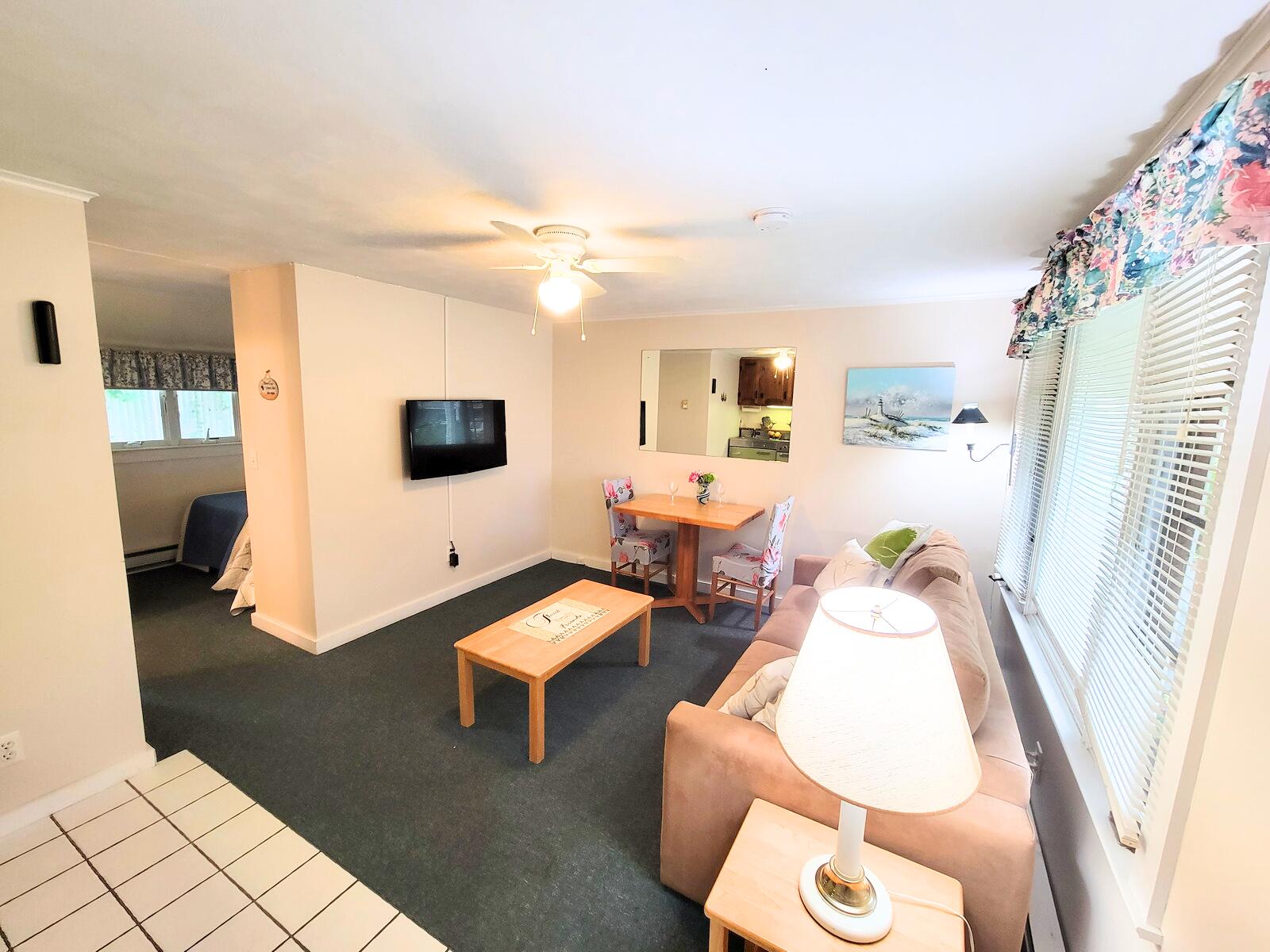 405 Lower County Road, Unit 23 Harwich Port, MA 02646 - Photo 13 of 24 a living room with furniture and a flat screen tv