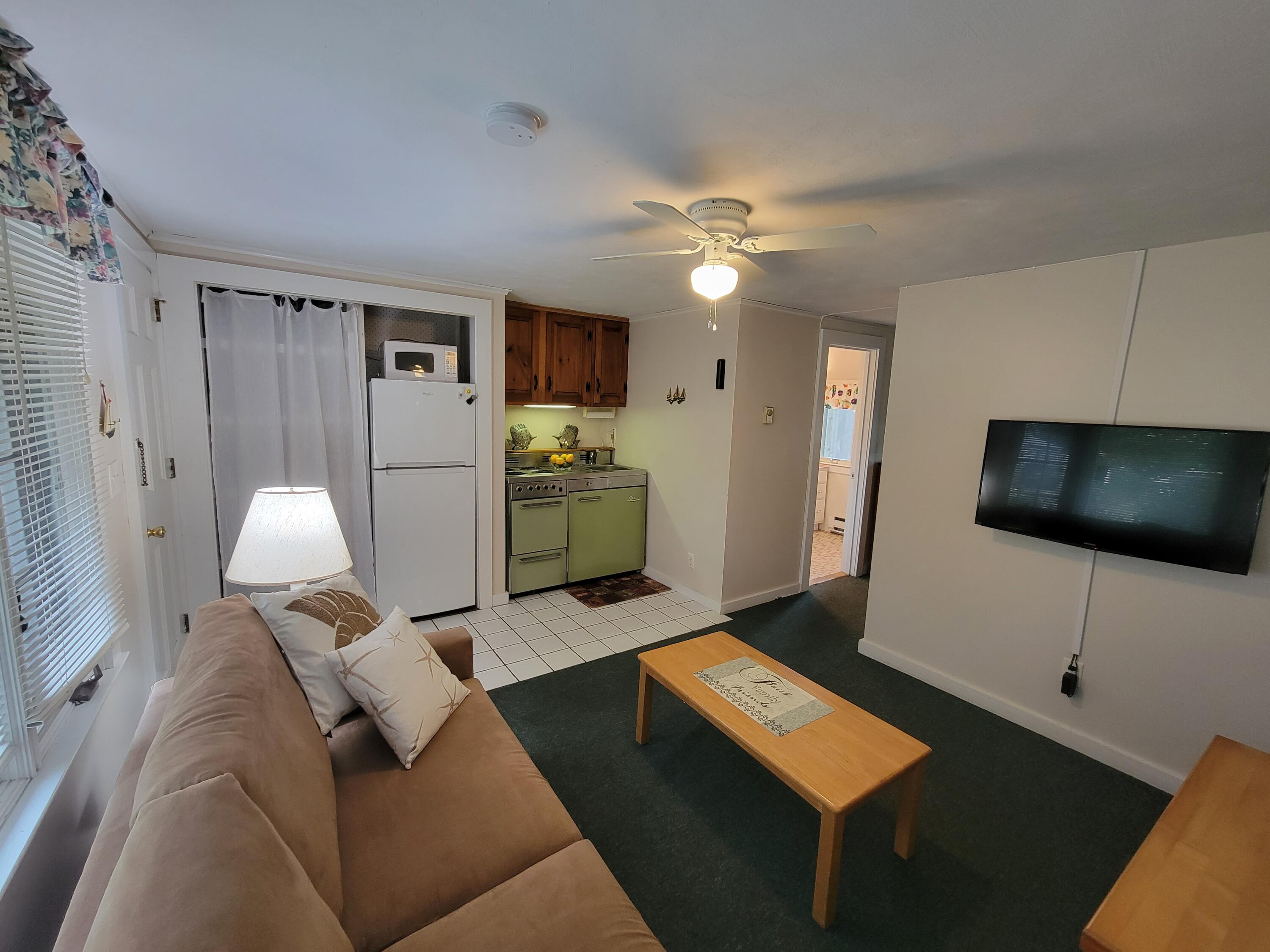 405 Lower County Road, Unit 23 Harwich Port, MA 02646 - Photo 16 of 24 a living room with furniture and a flat screen tv