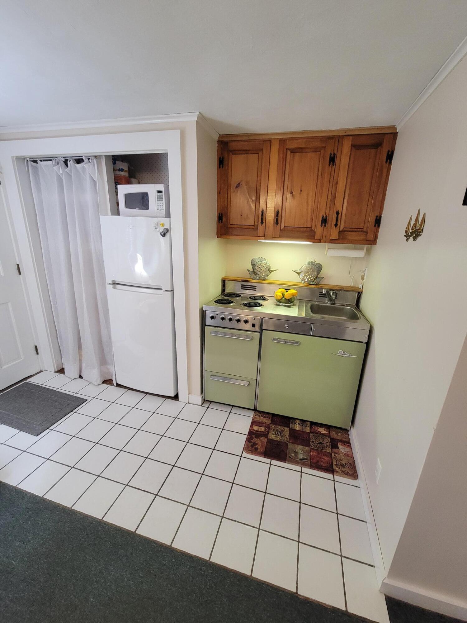405 Lower County Road, Unit 23 Harwich Port, MA 02646 - Photo 17 of 24 a kitchen with a refrigerator sink and cabinets