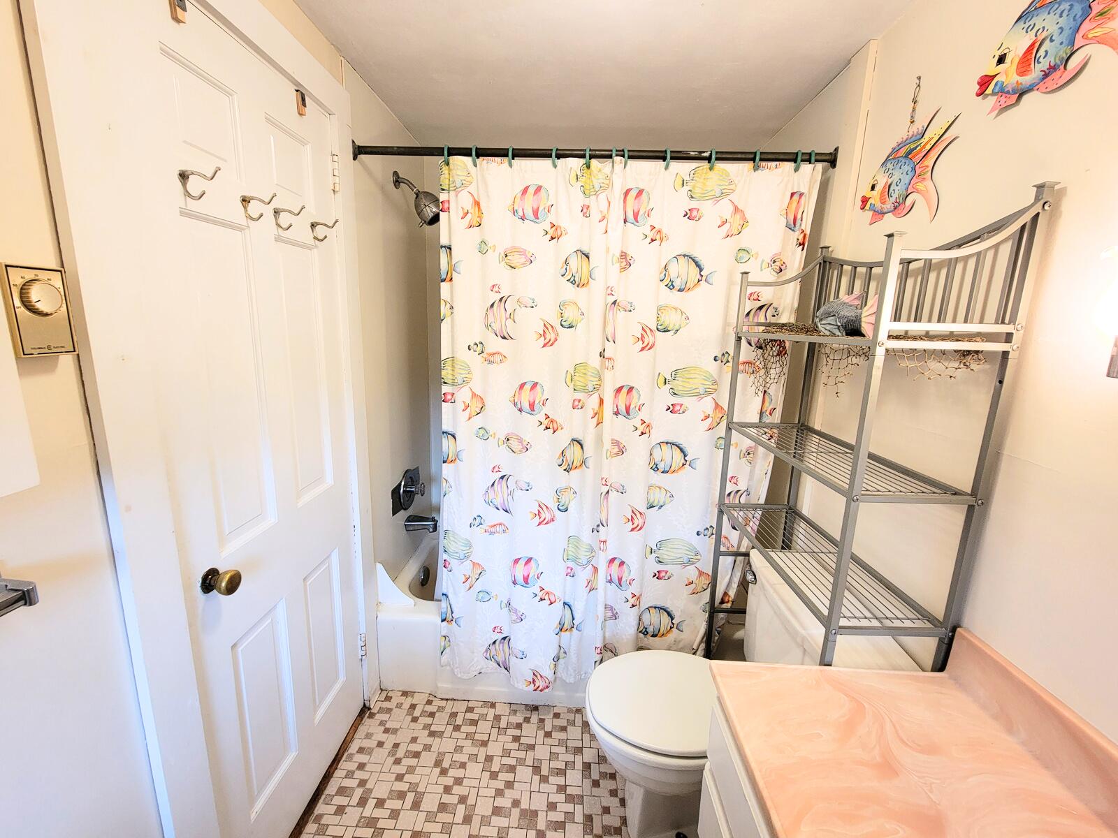 405 Lower County Road, Unit 23 Harwich Port, MA 02646 - Photo 19 of 24 a bathroom with a toilet and a shower curtain