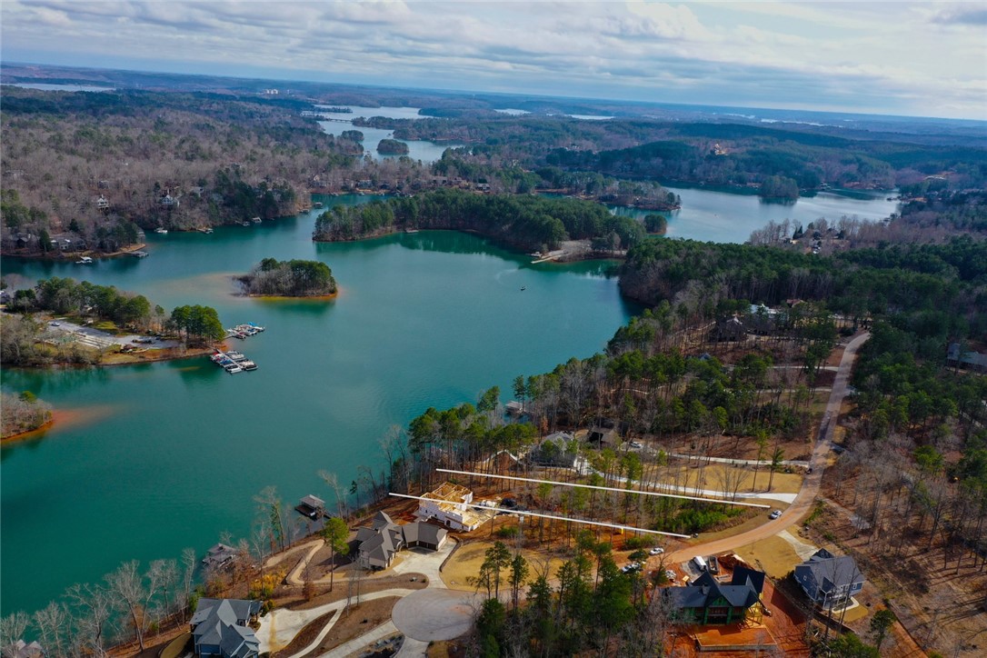 Lot 131 Harbor Point Seneca, SC 29672 - Photo 13 of 48 This aerial view showcases a vibrant waterfront community nestled among lush forests and a sparkling lake.