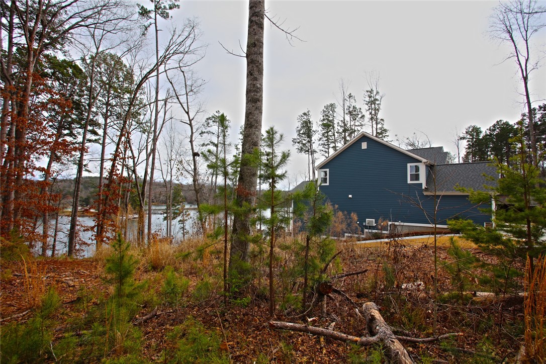 Lot 131 Harbor Point Seneca, SC 29672 - Photo 42 of 48 This tranquil lakeside property offers a serene escape, surrounded by natural beauty and mature trees.