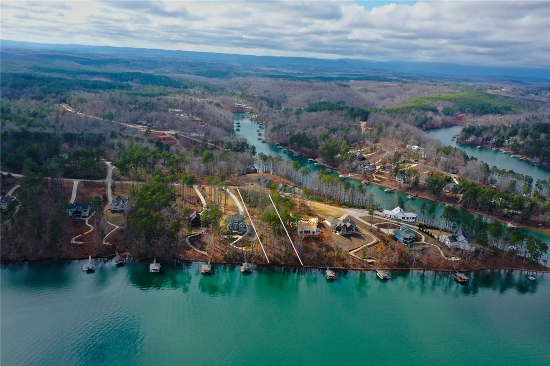 Lot 131 Harbor Point Seneca, SC 29672 - Photo 8 of 48 This aerial view showcases a picturesque waterfront community nestled among a lush, wooded landscape.