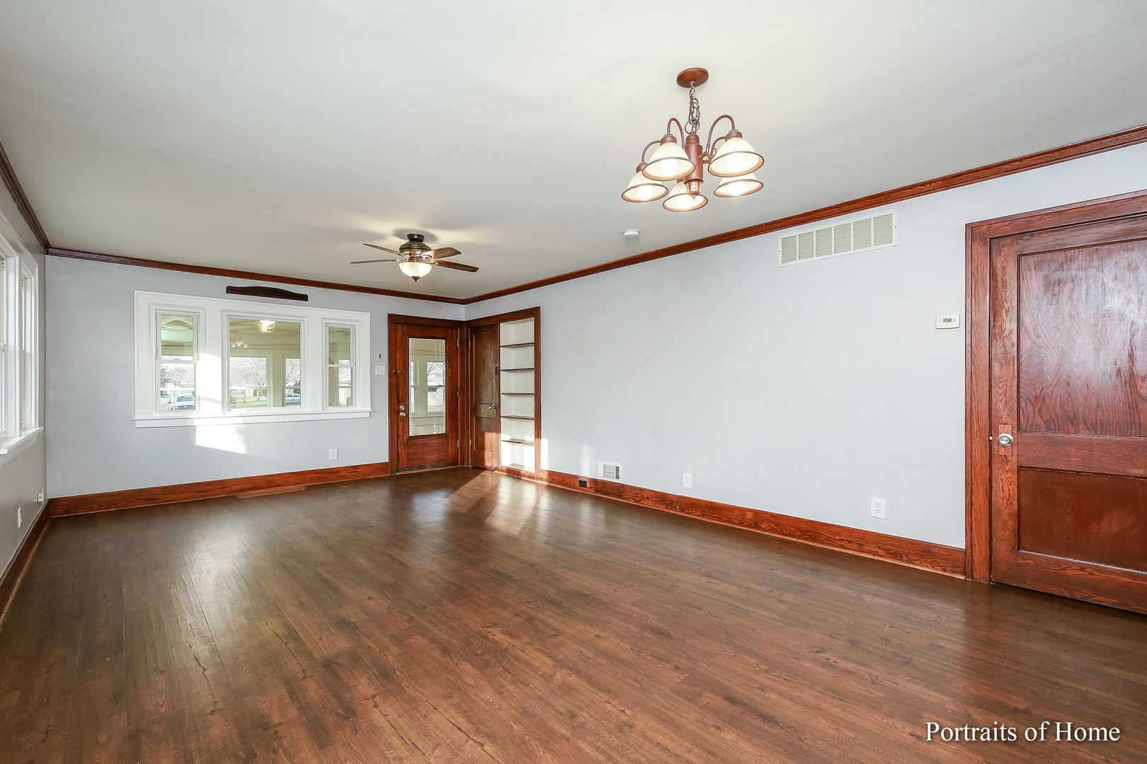 952 Black Road Joliet, IL 60435 - Photo 4 of 25 an empty room with wooden floor chandelier and windows