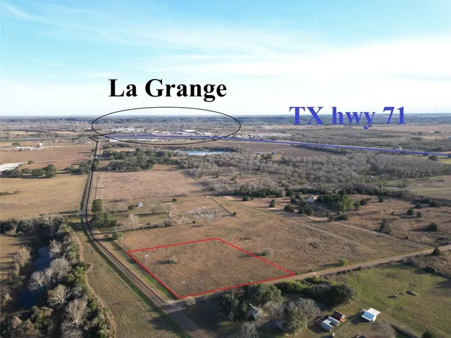 a view of a dry yard with wooden fence