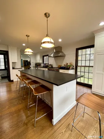 a kitchen with kitchen island stainless steel appliances a stove center island a table and chairs