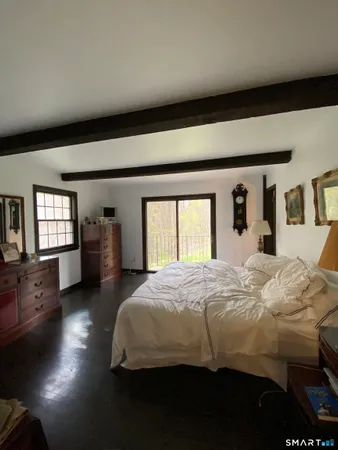 a bedroom with a large bed and dresser with chair