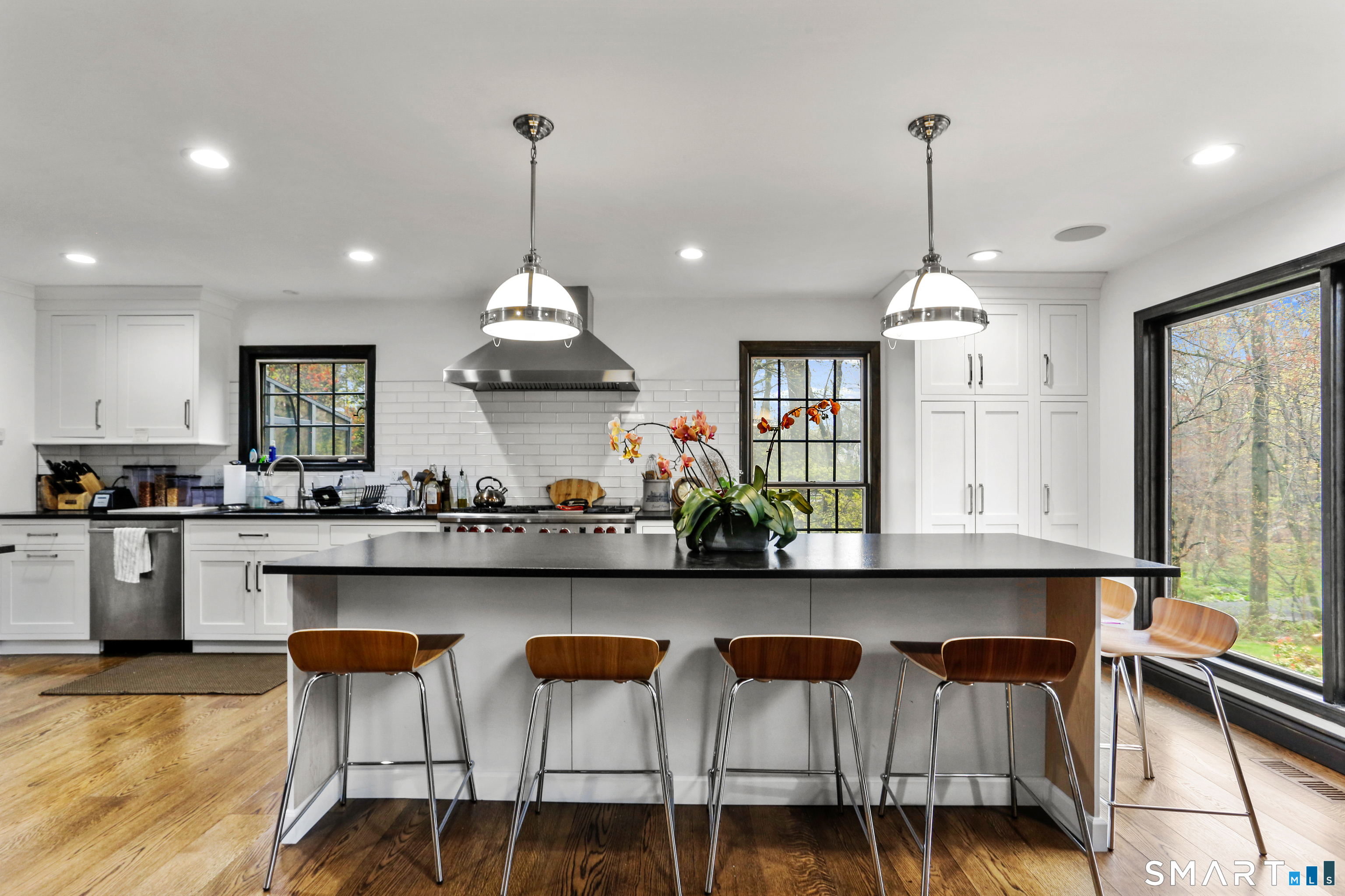 488 Cognewaugh Road Greenwich, CT 06807 - Photo 10 of 40 a kitchen with stainless steel appliances granite countertop a sink a stove top oven a dining table and chairs with wooden floor