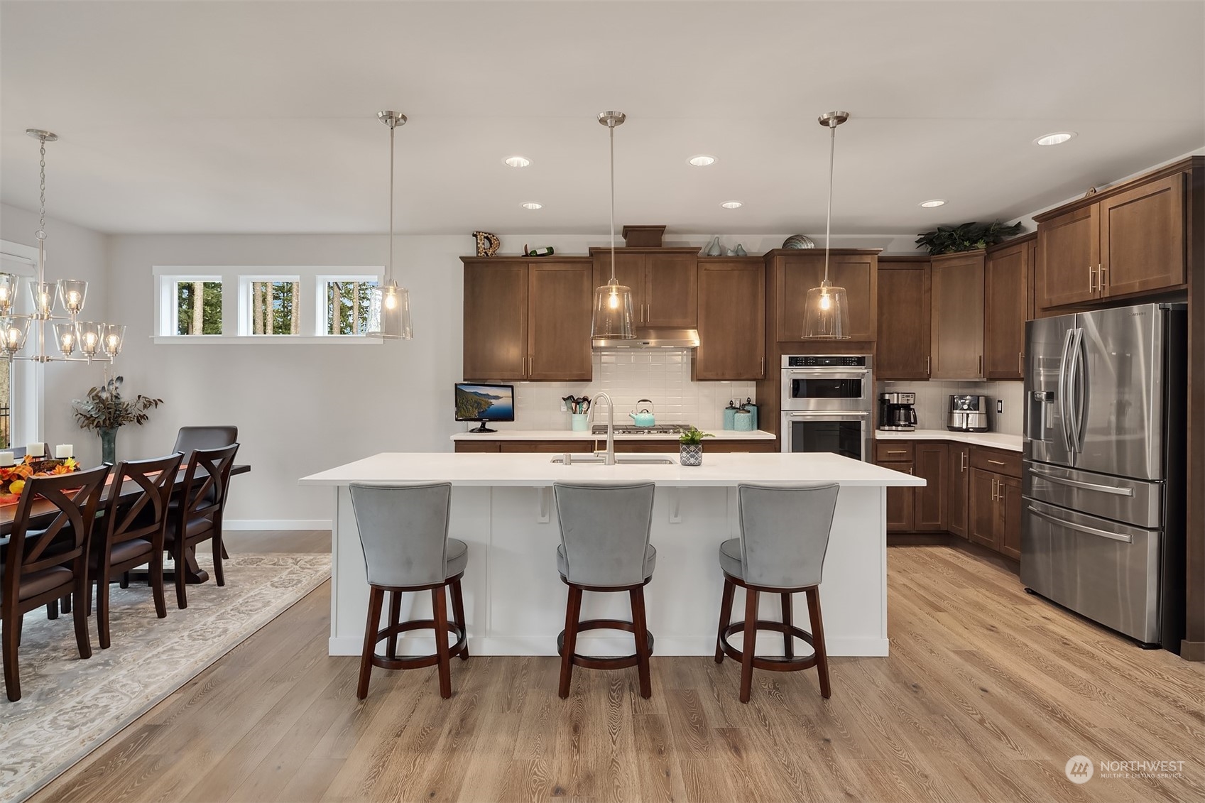 4331 Caddyshack Drive Northeast Lacey, WA 98516 - Photo 13 of 34 a kitchen with stainless steel appliances kitchen island granite countertop a dining table chairs and granite counter tops
