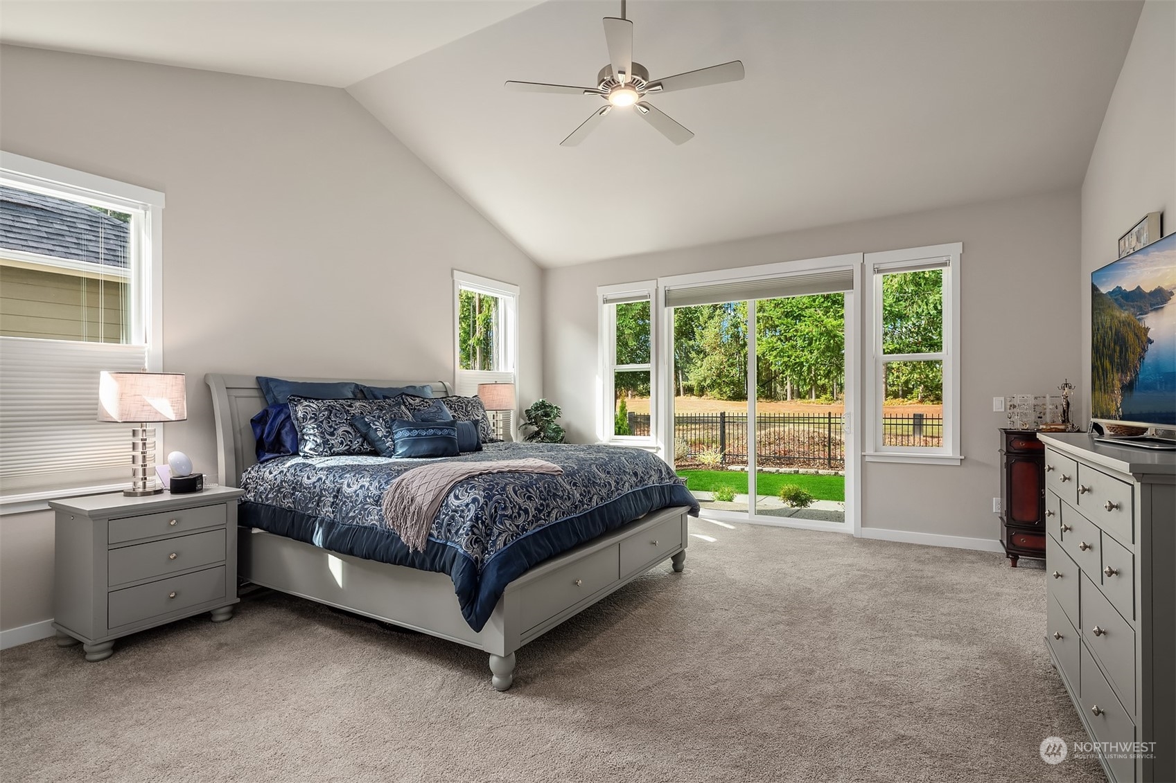 4331 Caddyshack Drive Northeast Lacey, WA 98516 - Photo 20 of 34 a spacious bedroom with a bed and a flat tv screen on dresser