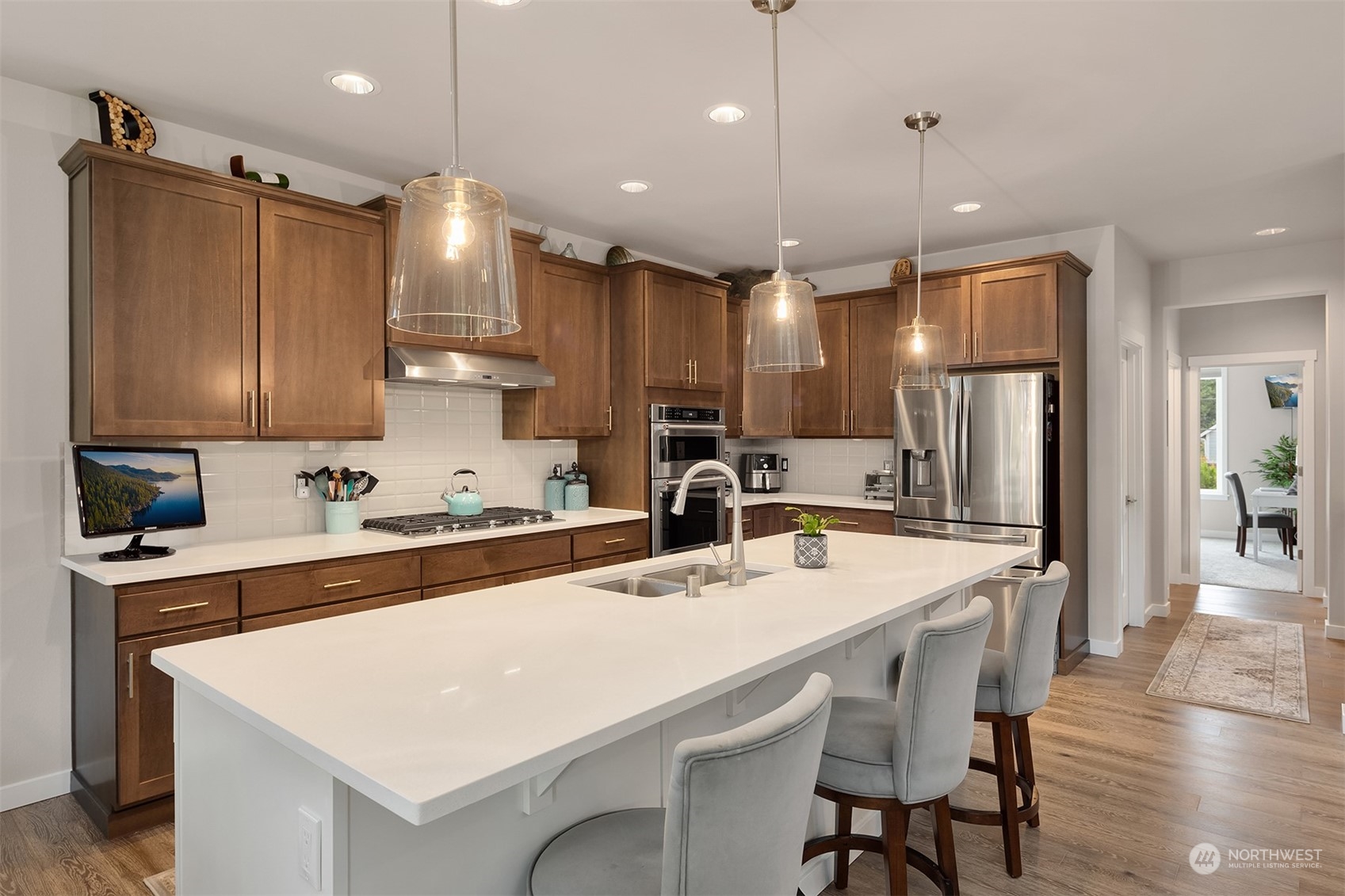 4331 Caddyshack Drive Northeast Lacey, WA 98516 - Photo 8 of 34 a kitchen with stainless steel appliances kitchen island a table chairs refrigerator and microwave