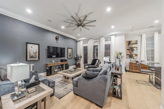 a living room with furniture a flat screen tv and a large window