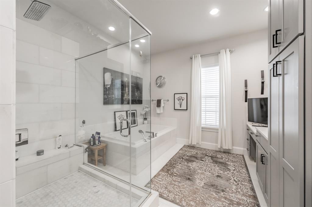 7333 Valley View Lane, Unit 902 Dallas, TX 75240 - Photo 22 of 40 a spacious bathroom with a double vanity sink a mirror a bathtub and shower