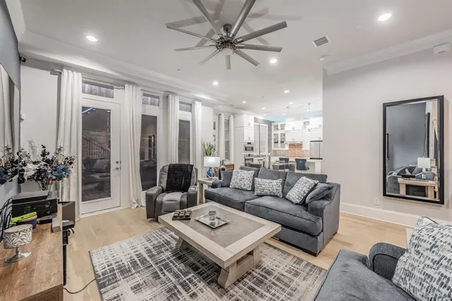 a living room with furniture kitchen view and a large window