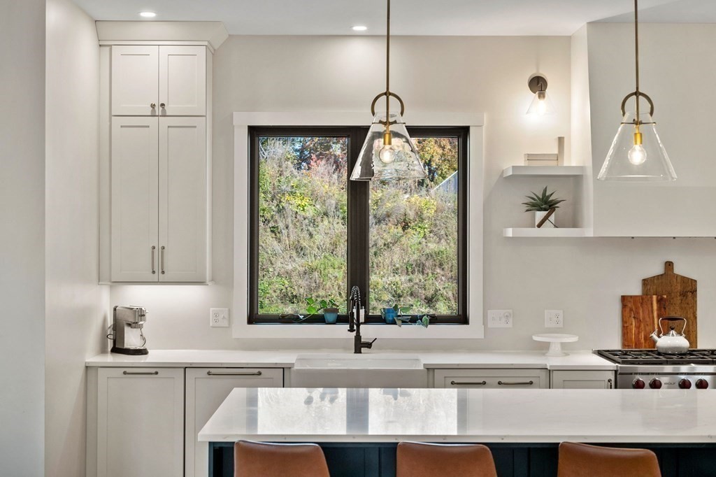 35 Hitching Post Road North Andover, MA 01845 - Photo 19 of 42 a kitchen with kitchen island granite countertop a sink cabinets and a large window