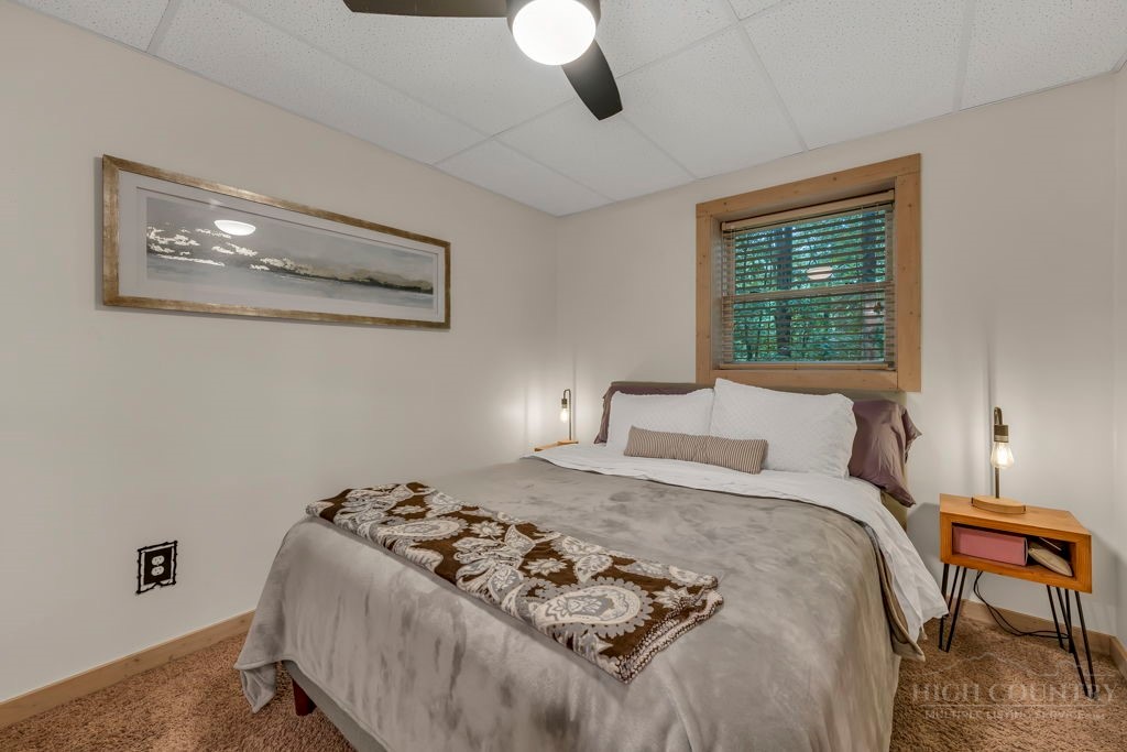 192 Dewitt Barnett Road Vilas, NC 28692 - Photo 29 of 32 a bedroom with a bed and a chandelier