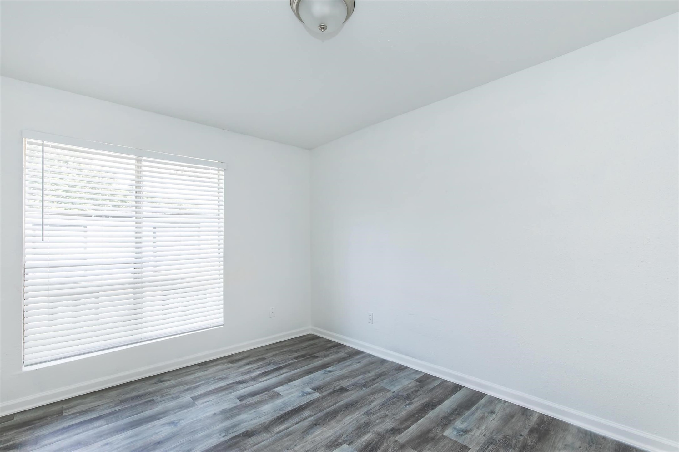 18001 Cypress Trace Road, Unit 201 Houston, TX 77090 - Photo 13 of 31 a view of an empty room with wooden floor and a window