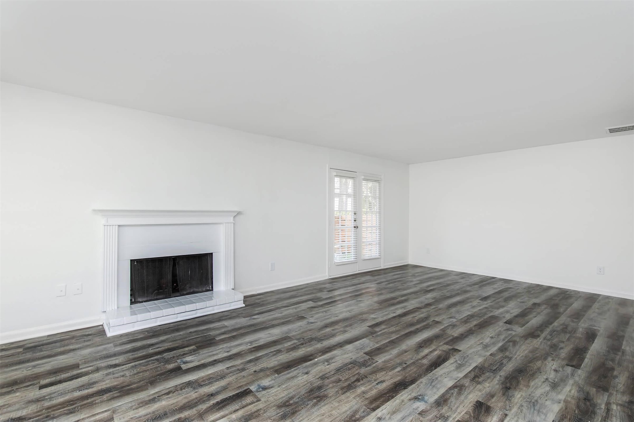 18001 Cypress Trace Road, Unit 201 Houston, TX 77090 - Photo 2 of 31 a view of an empty room with wooden floor fireplace and a window